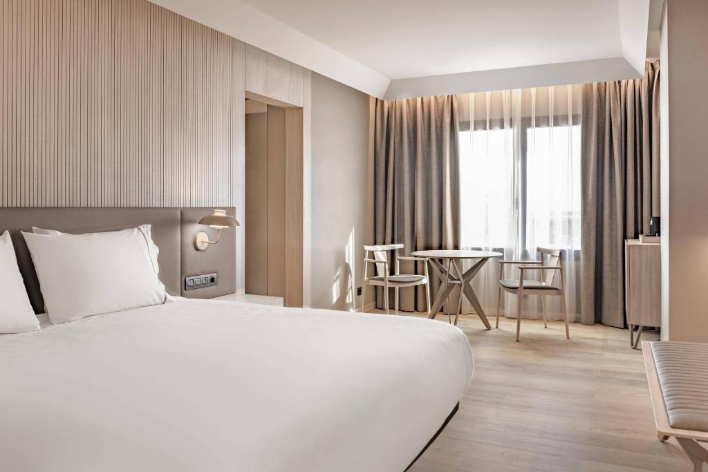 a hotel room with a large bed and a table at AC Hotel by Marriott Tenerife in Santa Cruz de Tenerife