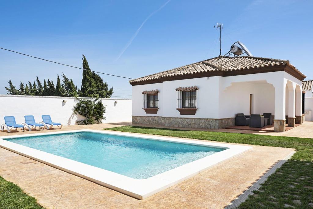 a swimming pool in front of a house at Vivienda Rural El chiclanero in Conil de la Frontera