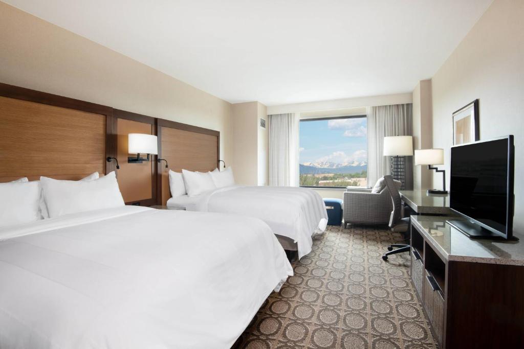 a hotel room with two beds and a flat screen tv at Denver Marriott Westminster in Westminster