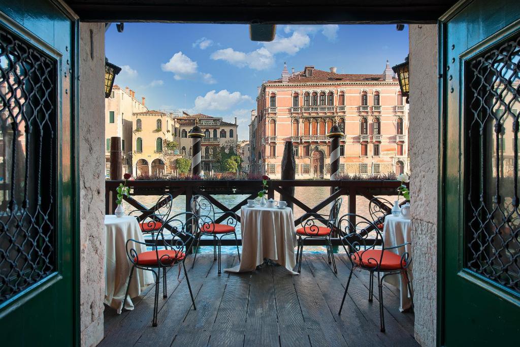 a balcony with tables and chairs with a view of the city at Residenza d'Epoca San Cassiano in Venice