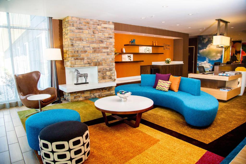 a living room with a blue couch and a fireplace at Fairfield Inn & Suites by Marriott Pocatello in Pocatello