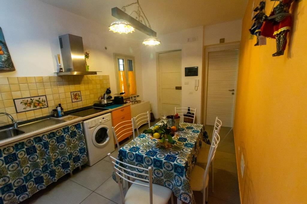 a kitchen with a table and a washing machine at La Zagara in Aci Castello