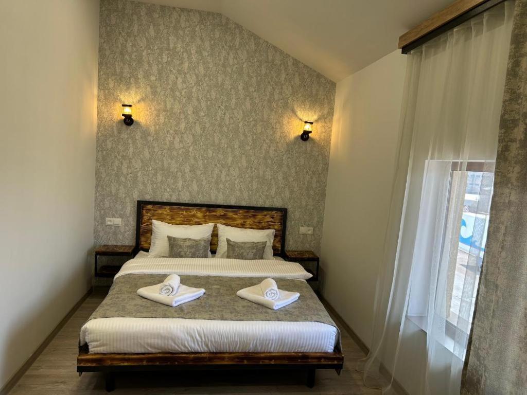 een slaapkamer met een bed met twee handdoeken erop bij WaterFall Hotel in Jerevan