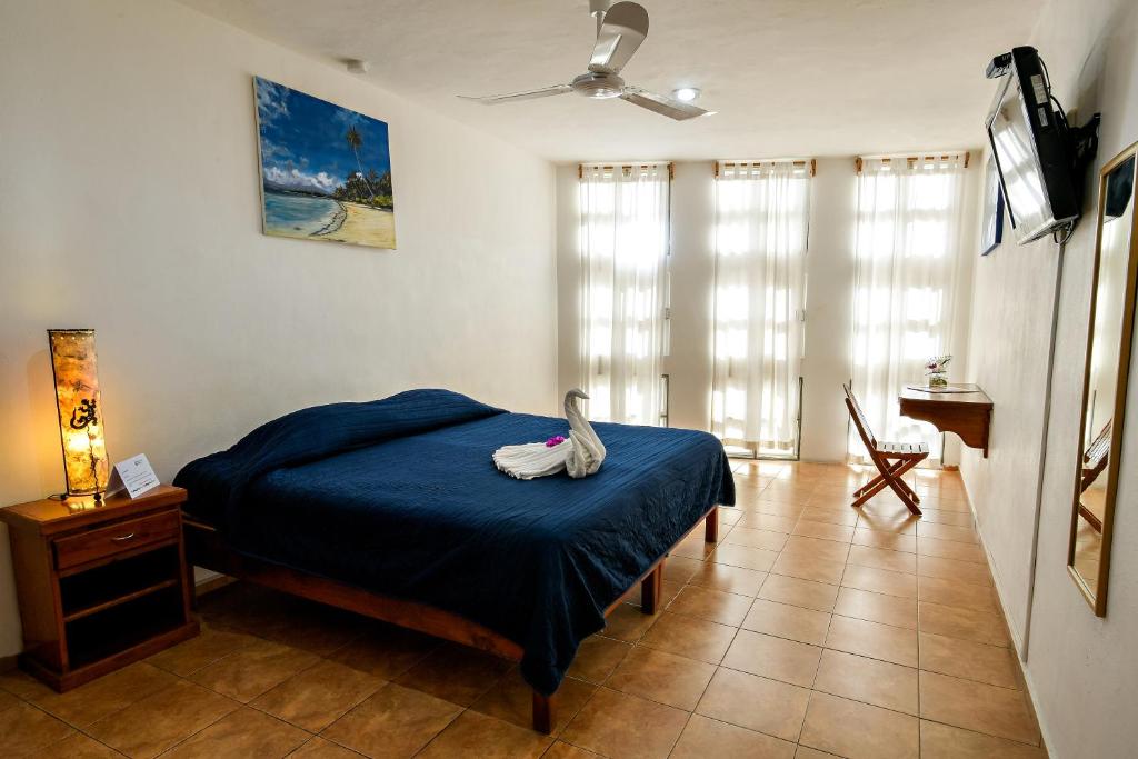 Un dormitorio con una cama con un cisne. en International House en Playa del Carmen