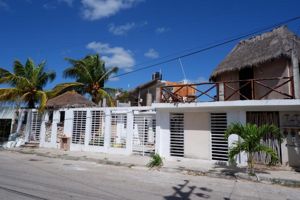 a white house with white shutters on a street at Casa Chi in Valladolid