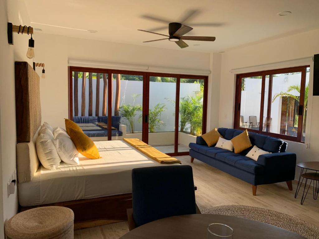un soggiorno con un letto e un divano di Luana Suites- Suite Aruma a Zihuatanejo