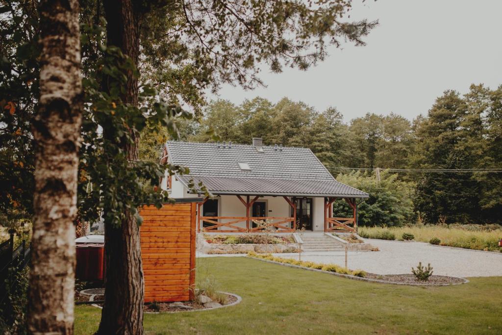 a house with a brick wall in a garden at Pasieka Podlaska Tradycja in Siemiatycze