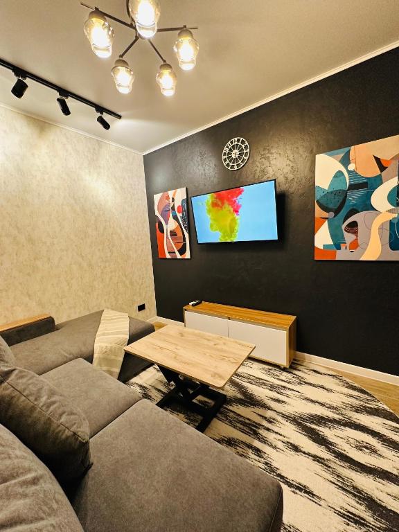 a living room with a couch and a flat screen tv at Yas 2 Apartment in Samarkand