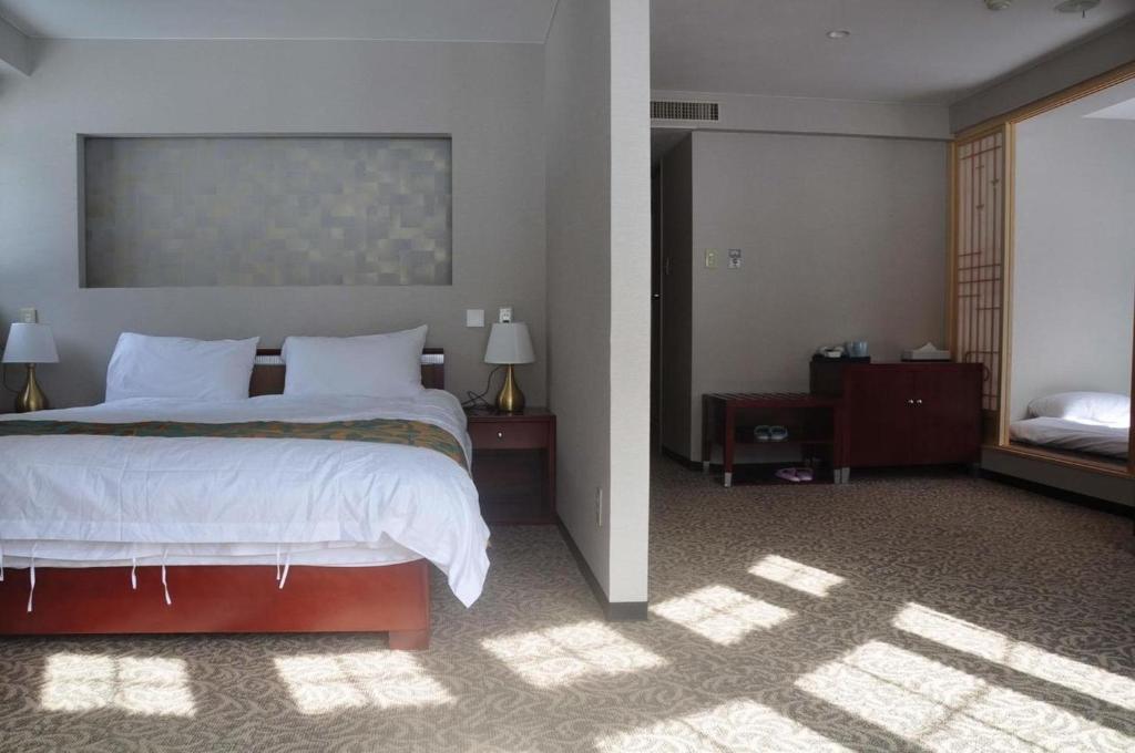 a bedroom with a large bed with white sheets at Hakuba Sun Valley Hotel Annex - Vacation STAY 90355v in Iida
