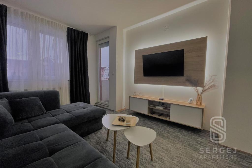 uma sala de estar com um sofá e uma televisão em Apartman Sergej em Sarajevo