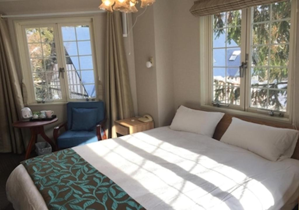 Iida的住宿－Hakuba Sun Valley Hotel Annex - Vacation STAY 90337v，一间卧室设有一张大床和两个窗户。