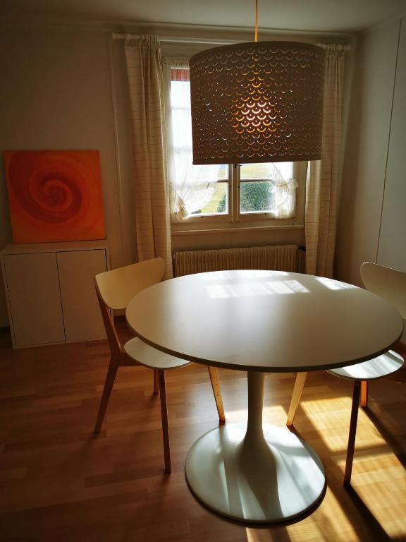 a table and chairs in a room with a window at Marmottin in Luzern