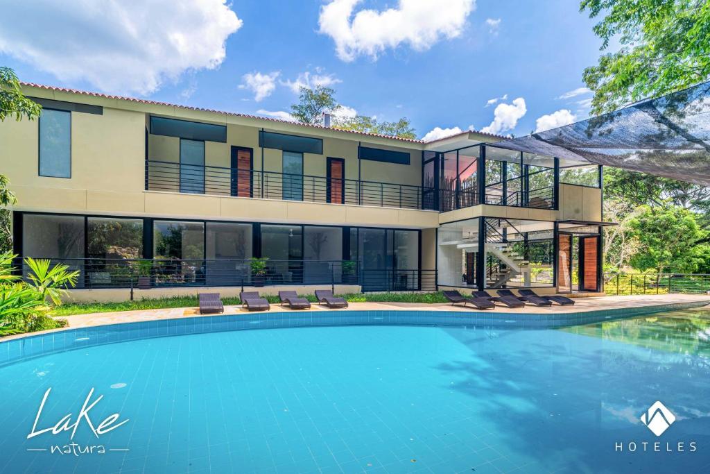 a house with a swimming pool in front of it at Natura Lake - Casa Campestre in Anapoima