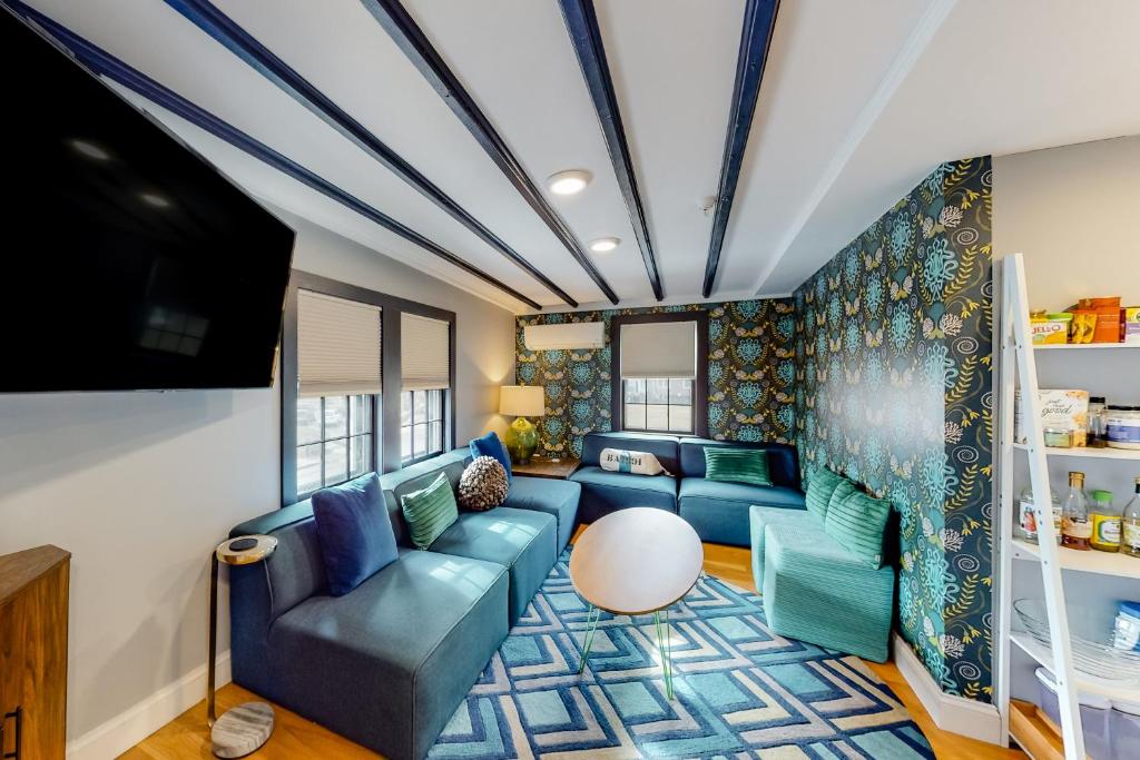a living room with a blue couch and a tv at Cape Cod Mod in Provincetown