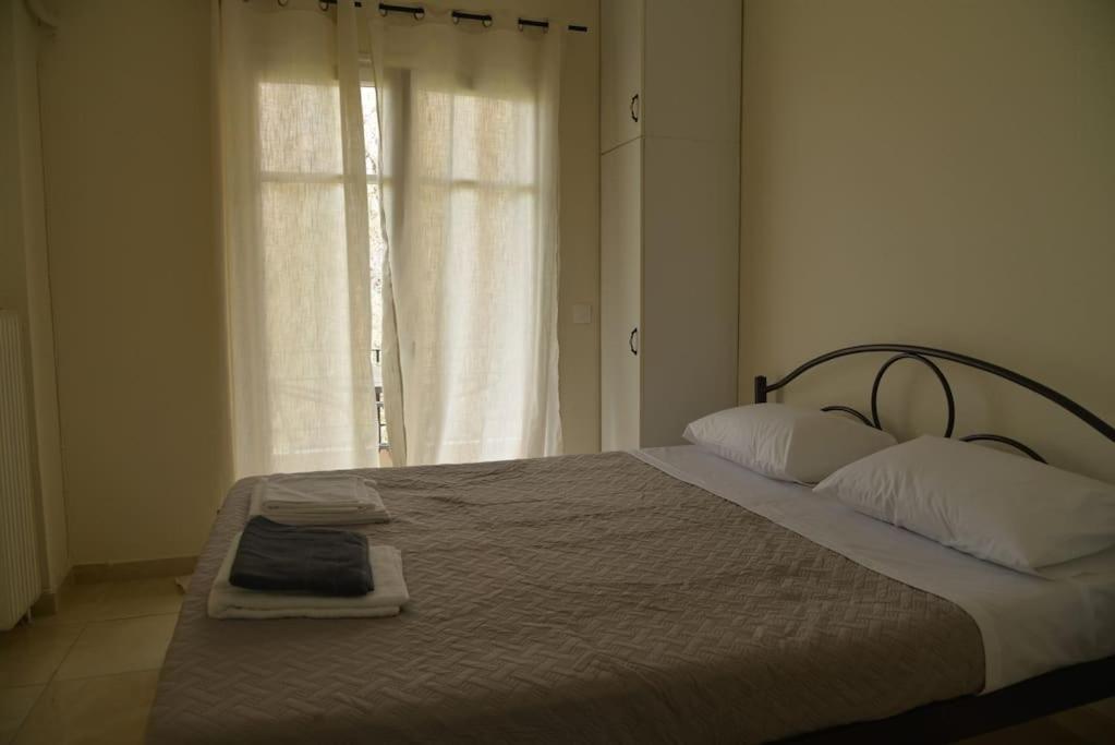una camera da letto con un letto con due cuscini e una finestra di little apartment in kanoni a Análipsis