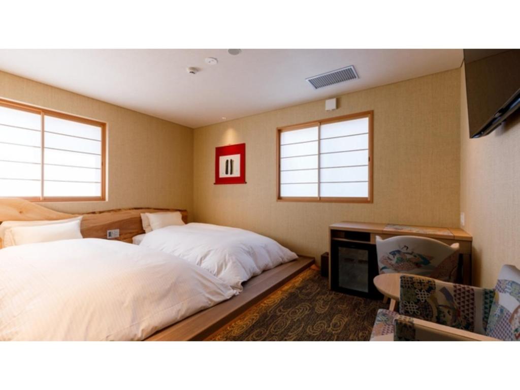 1 Schlafzimmer mit 2 Betten und einem Flachbild-TV in der Unterkunft Hotel Rashiku Kanazawa - Vacation STAY 49686v in Kanazawa