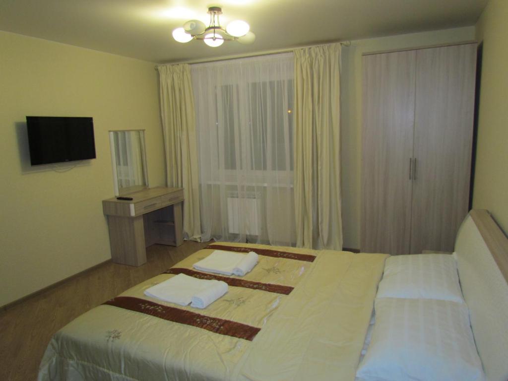 ヴォログダにあるАпартаменты на Новгородской 4のベッドとテレビが備わるホテルルームです。
