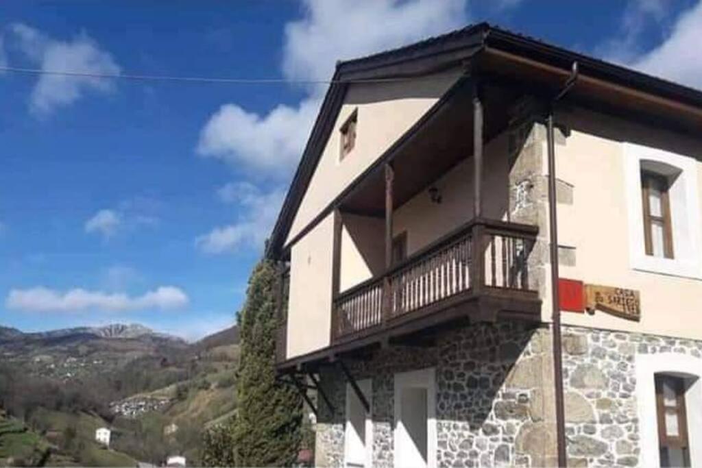 - un bâtiment avec un balcon sur le côté dans l'établissement CASONA SARIEGO, APARTAMENTO, à La Vega de Riosa