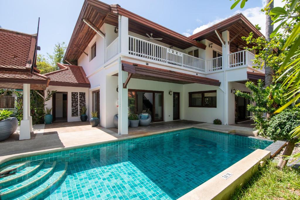 une villa avec une piscine en face d'une maison dans l'établissement Beachfront Resort Villa Baan Tawan 3BR, à Lamai