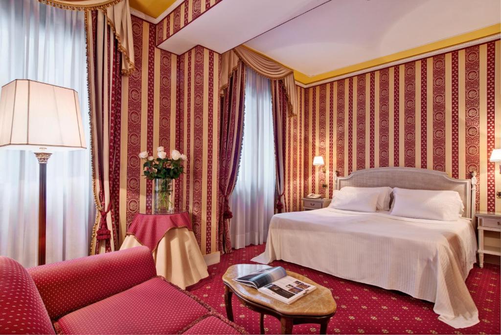 a bedroom with a bed and a couch and a table at Sina Palazzo Sant'Angelo in Venice