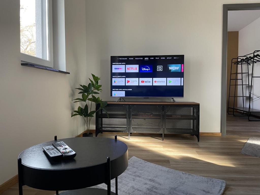 a living room with a flat screen tv on a stand at Neubauwohnung im Herzen Panketal in Kolonie Röntgental