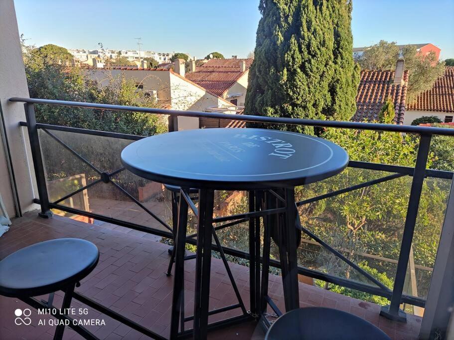 niebieski stół i dwa stołki na balkonie w obiekcie Superbe studio dans résidence avec piscine sans chambre mais couchage salle et lit superposé dans l'entrée w mieście Le Grau-du-Roi