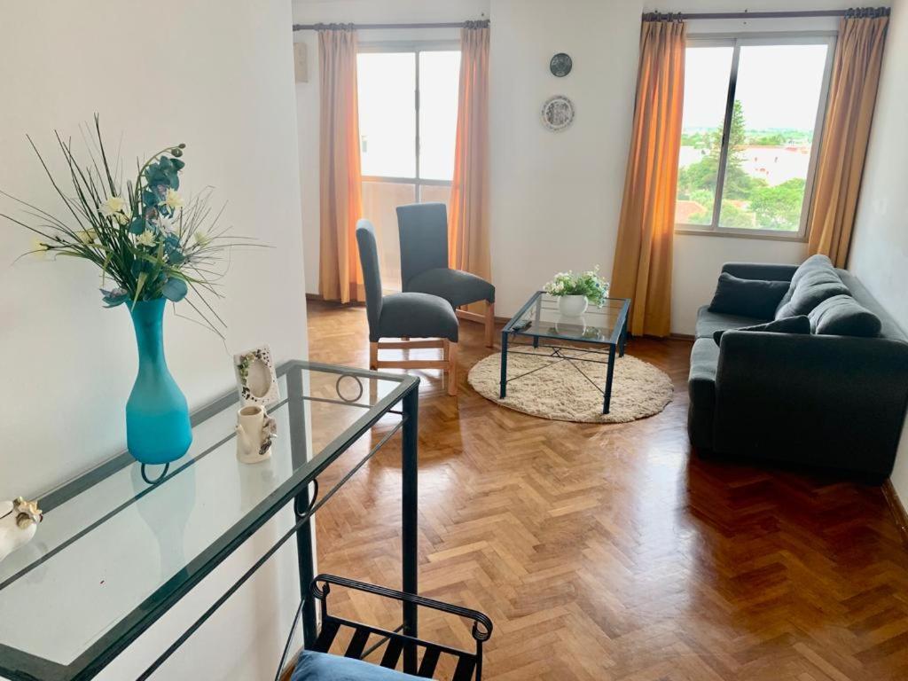 una sala de estar con un jarrón azul sobre una mesa de cristal en Departamento Center en San Fernando del Valle de Catamarca