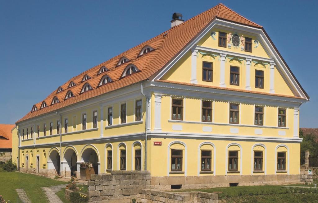 a large yellow building with a red roof at Penzion U Rychtářky in Holany