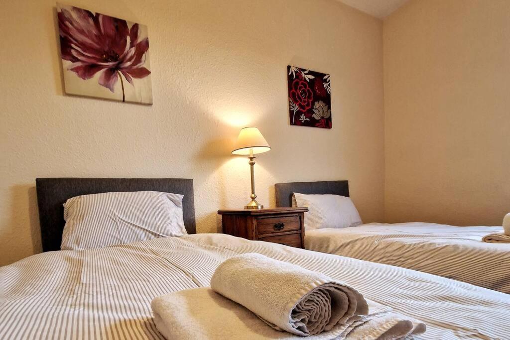 a hotel room with two beds with towels on them at Tallis House, Sleeps 5, near City Centre, Free Parking, Long or Short Stays - by NMB Property in Manchester