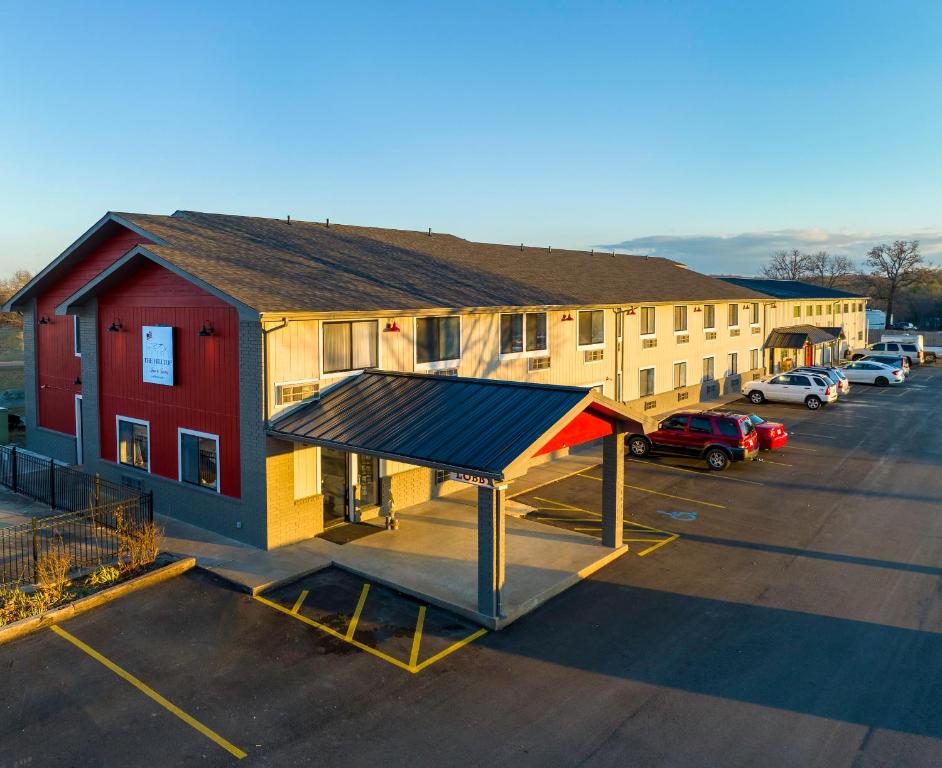 a bus stop in a parking lot next to a building at Hilltop Inn & Suites in Grove