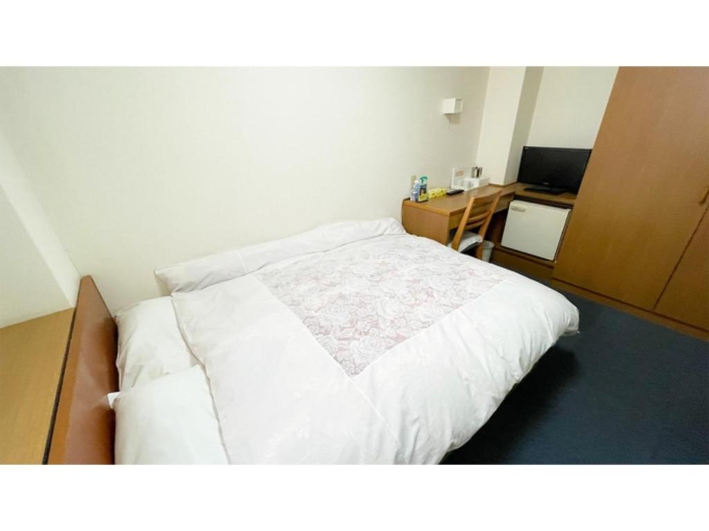 - une chambre avec un lit blanc et un bureau dans l'établissement Business Hotel Lupinus - Vacation STAY 55814v, à Takamatsu