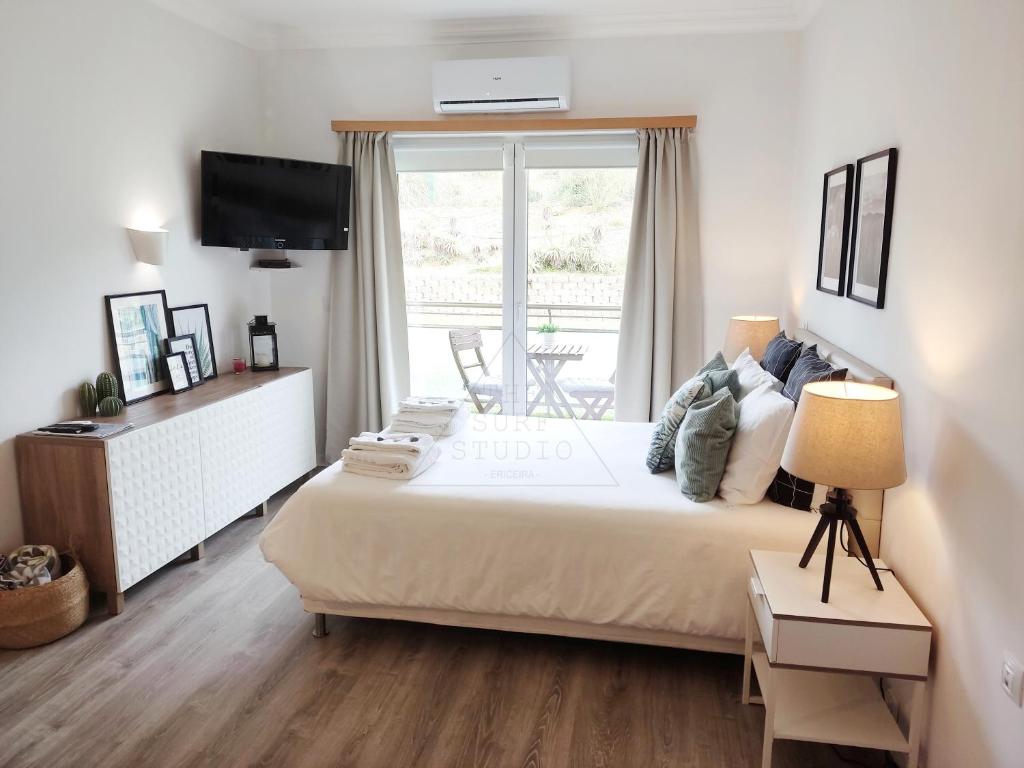 a bedroom with a large bed and a window at The Surf Studio - Ericeira in Ericeira