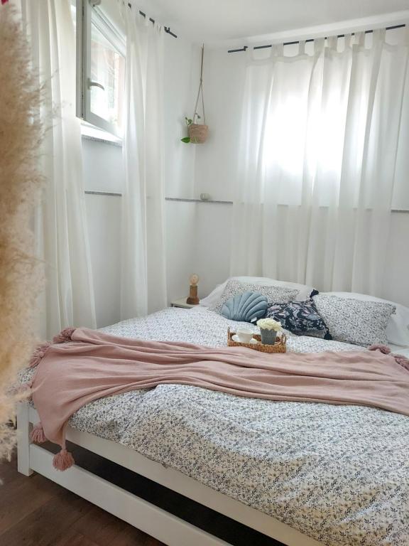 1 dormitorio con 1 cama con cortinas blancas en Apartment46 en Mali Lošinj