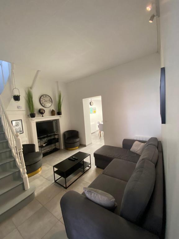 een woonkamer met een bank en een open haard bij L'amiénoise proche zenith stade cathédrale in Amiens