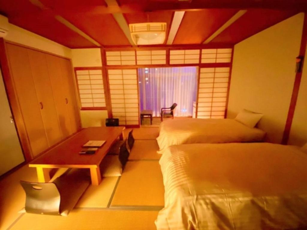 金山にあるIyashinoYado Akariya - Vacation STAY 74806vのベッド2台、デスク、窓が備わる客室です。