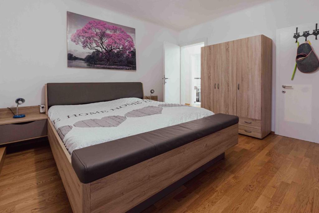 ザルツブルクにあるBenjamins Refugiumのベッドルーム1室(大型ベッド1台、木製キャビネット付)