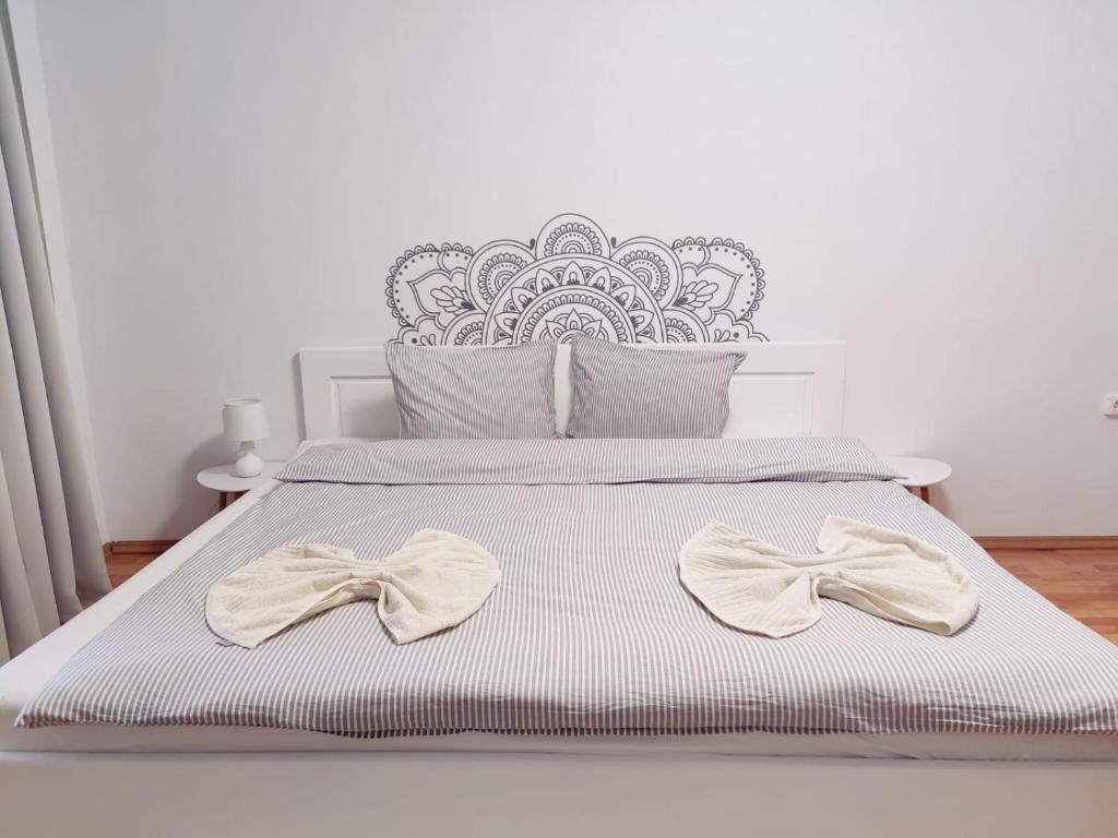een wit bed met twee witte bogen erop bij Penthouse Daniela in Târgu-Mureş