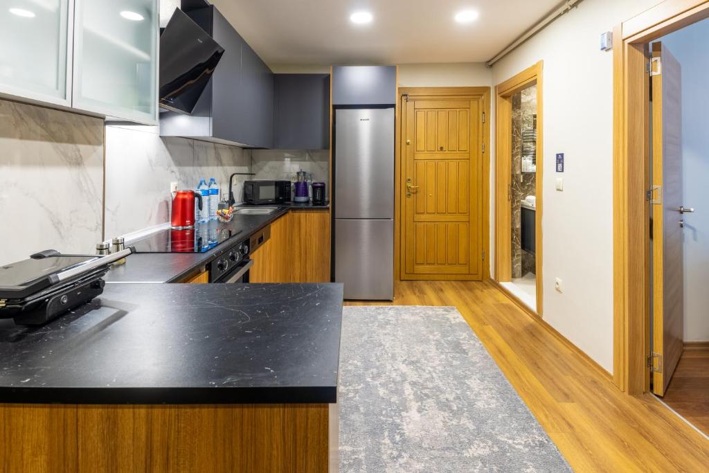 a kitchen with a black counter top and wooden cabinets at BayMari Suites Plus Florya in Istanbul