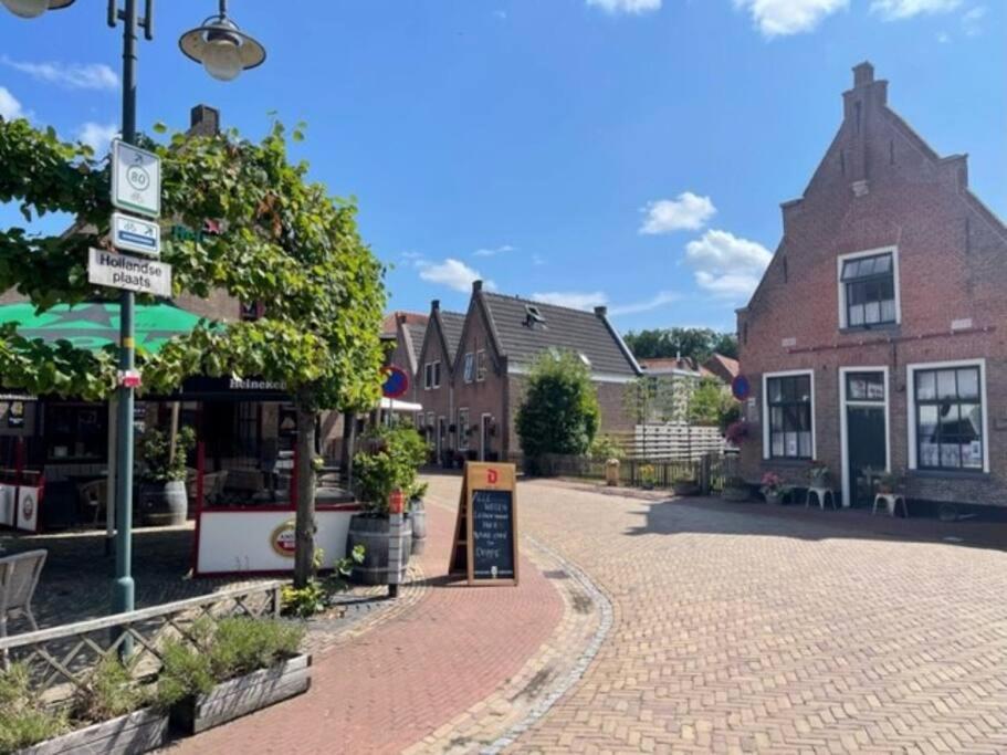 a cobblestone street in a town with a building at De Scheve Deur in Vollenhove