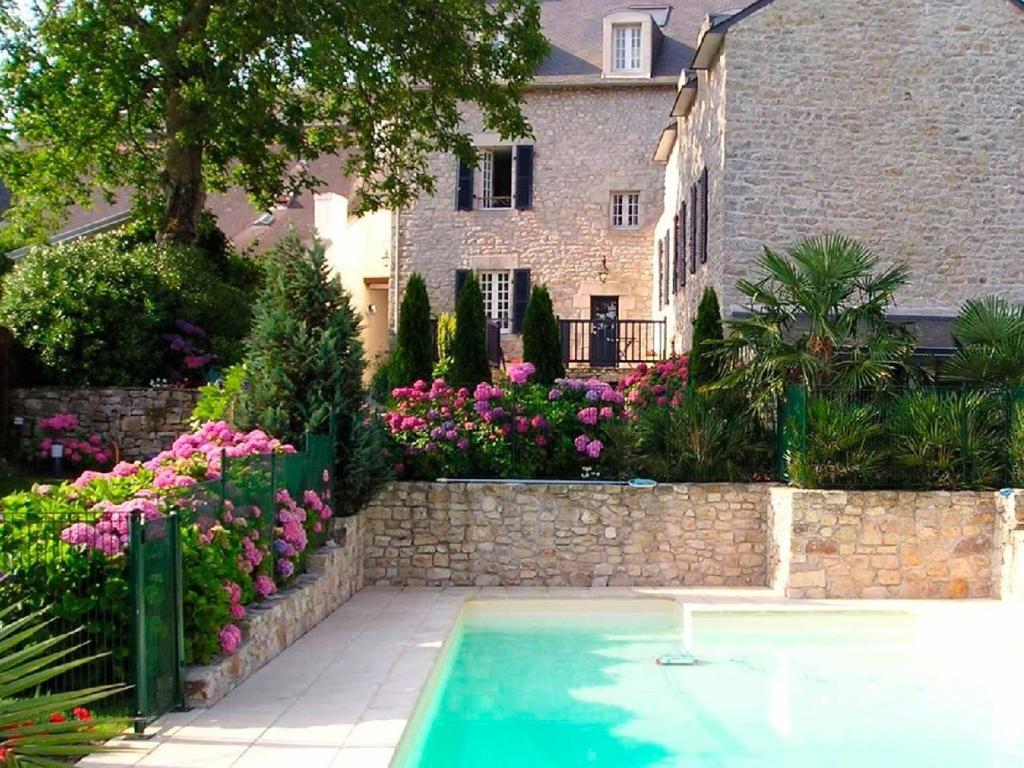 - une piscine en face d'une maison fleurie dans l'établissement Résidence Ti An Amiral, à Bénodet