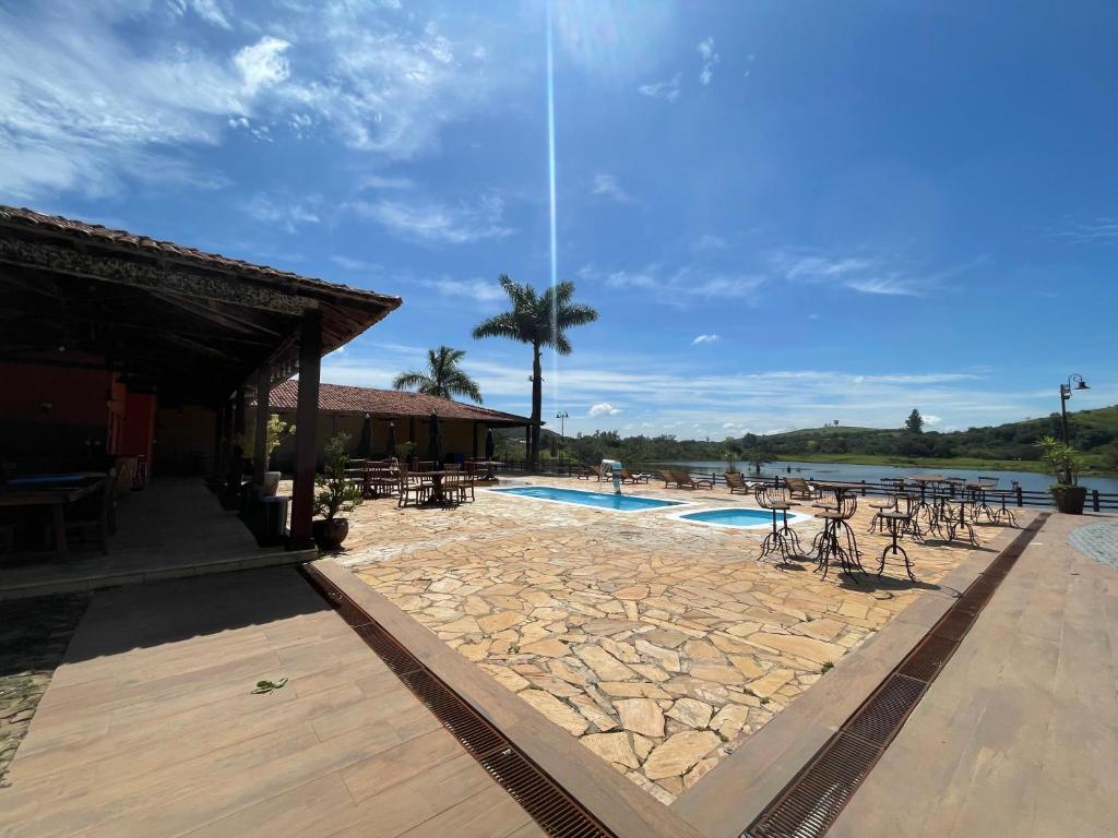 a resort with a pool and tables and chairs at Pousada Lagos de Minas in Santa Cruz de Minas