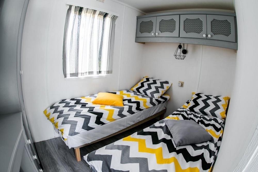 ein kleines Zimmer mit 2 Betten und einem Fenster in der Unterkunft Owls Camp in Karwieńskie Błoto Drugie