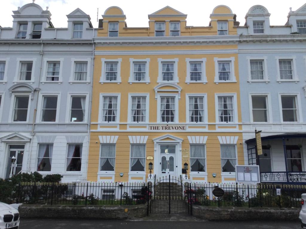 a yellow and white building with a sign on it at THE TREVONE, Llandudno in Llandudno