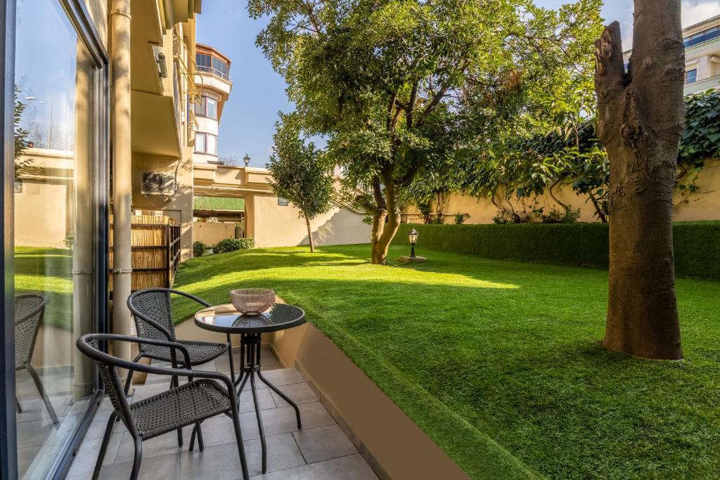 a patio with a table and chairs and a yard at BayMari Suites Plus Florya in Istanbul