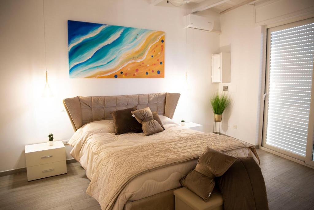 ein Schlafzimmer mit einem Bett und einem Wandgemälde in der Unterkunft Casa Vacanze Capitano in Porto Cesareo