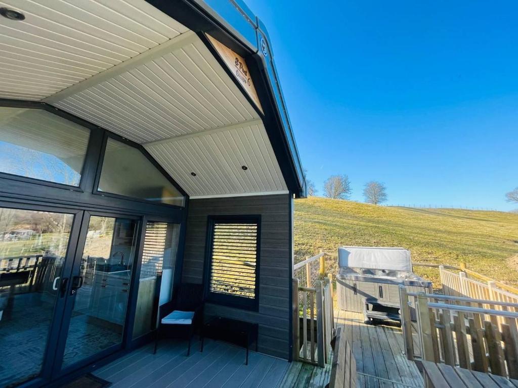 a house with a deck with a view of a field at Meadow Retreat in Rhayader