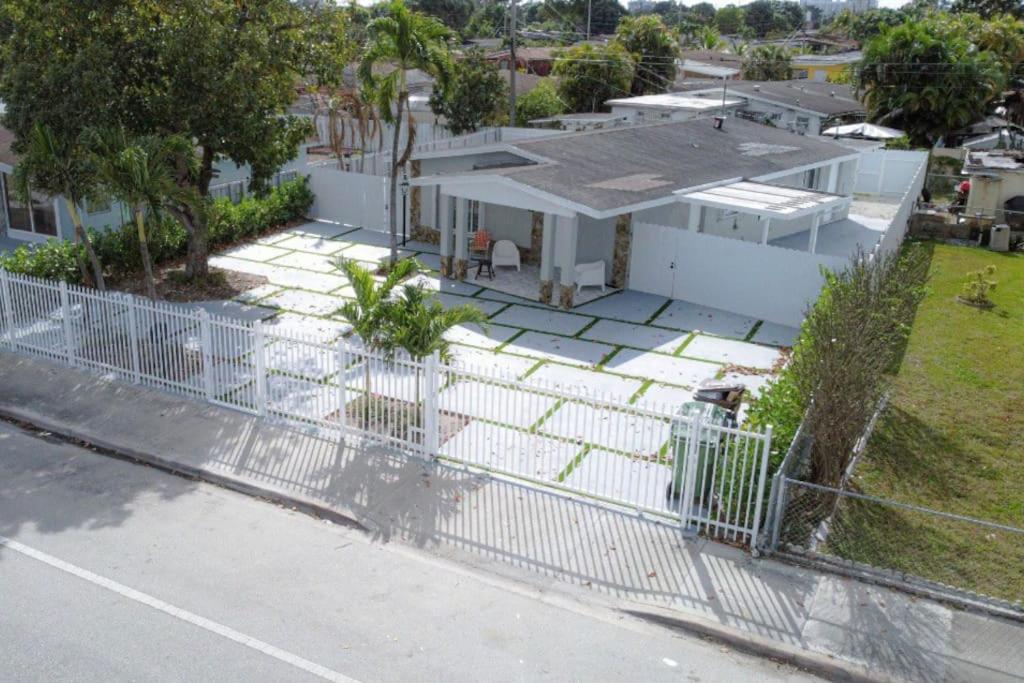 una cerca blanca frente a una casa blanca en Dream House 4B/2B King Bed Miami Springs, FL en Miami