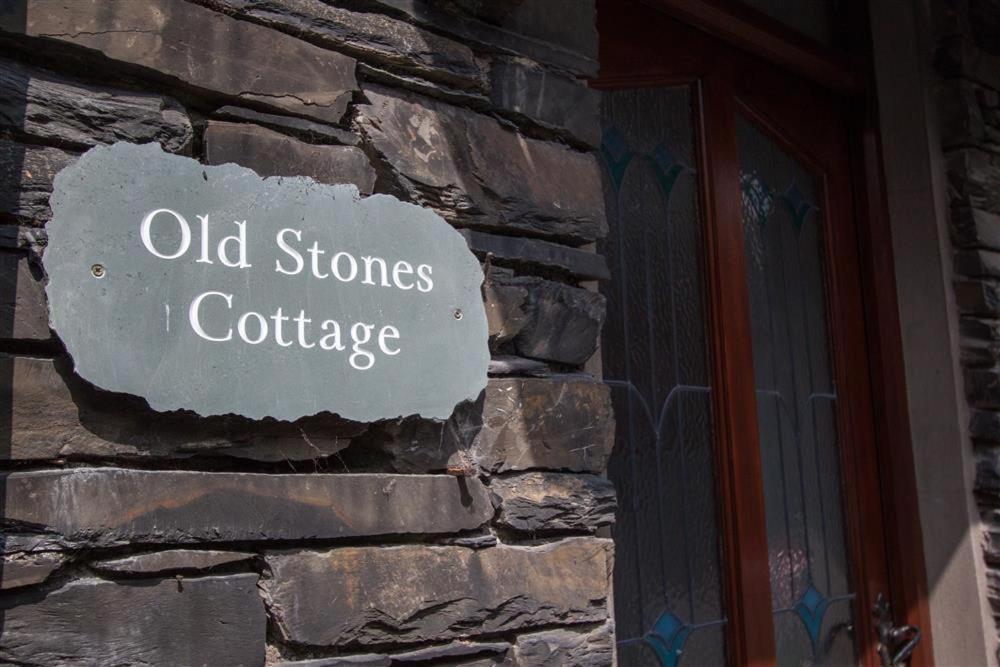 a stone wall with a sign that reads old stones i cottage at Old Stones Cottage in Ambleside