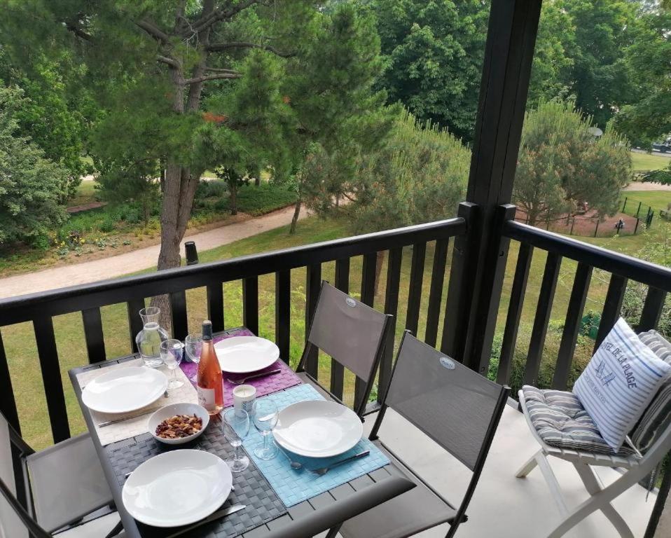 une table avec des assiettes et des bols de nourriture sur un balcon dans l'établissement #Bel appartement cosy Clos Mathilde !, à Cabourg