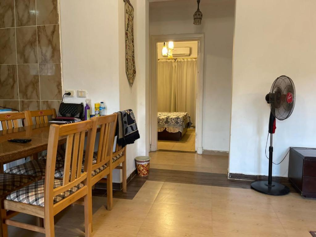 Zimmer mit einem Tisch und einem Ventilator in einem Zimmer in der Unterkunft Marsilia blue bay in Ain Suchna